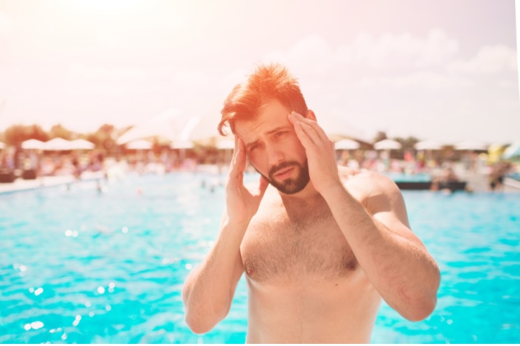 uomo che si tocca testa in piscina 