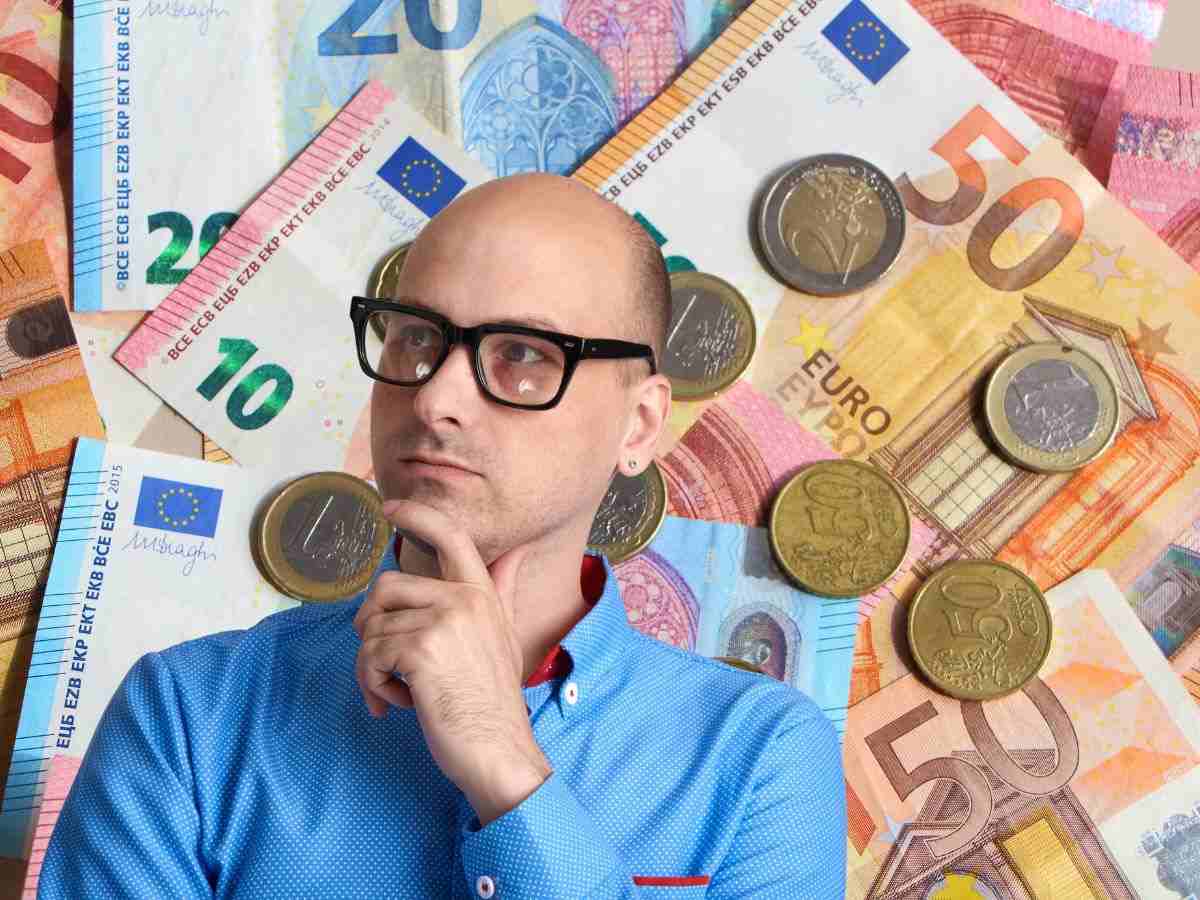 sfondo banconote e monete euro e ragazzo che pensa