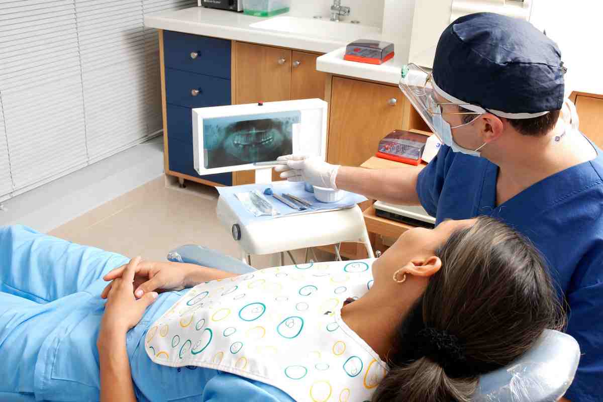 Dentista che mostra lastra a una donna