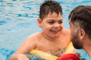 bambino in piscina con padre