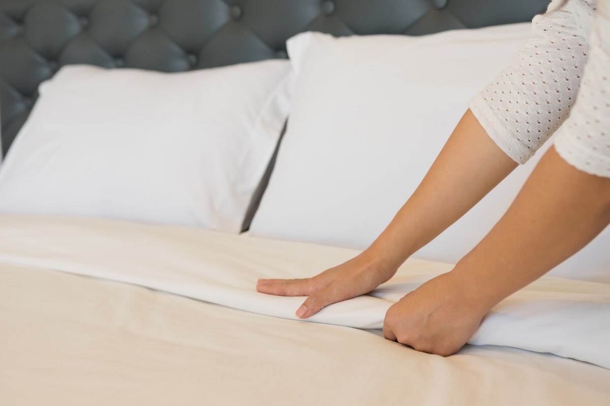 donna che sistema letto