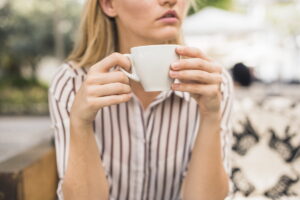 Donna seduta con tazza di caffè in mano
