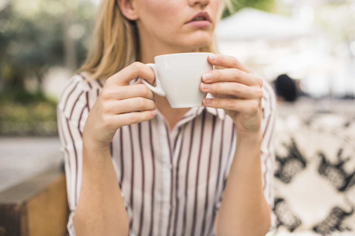 Donna seduta con tazza di caffè in mano