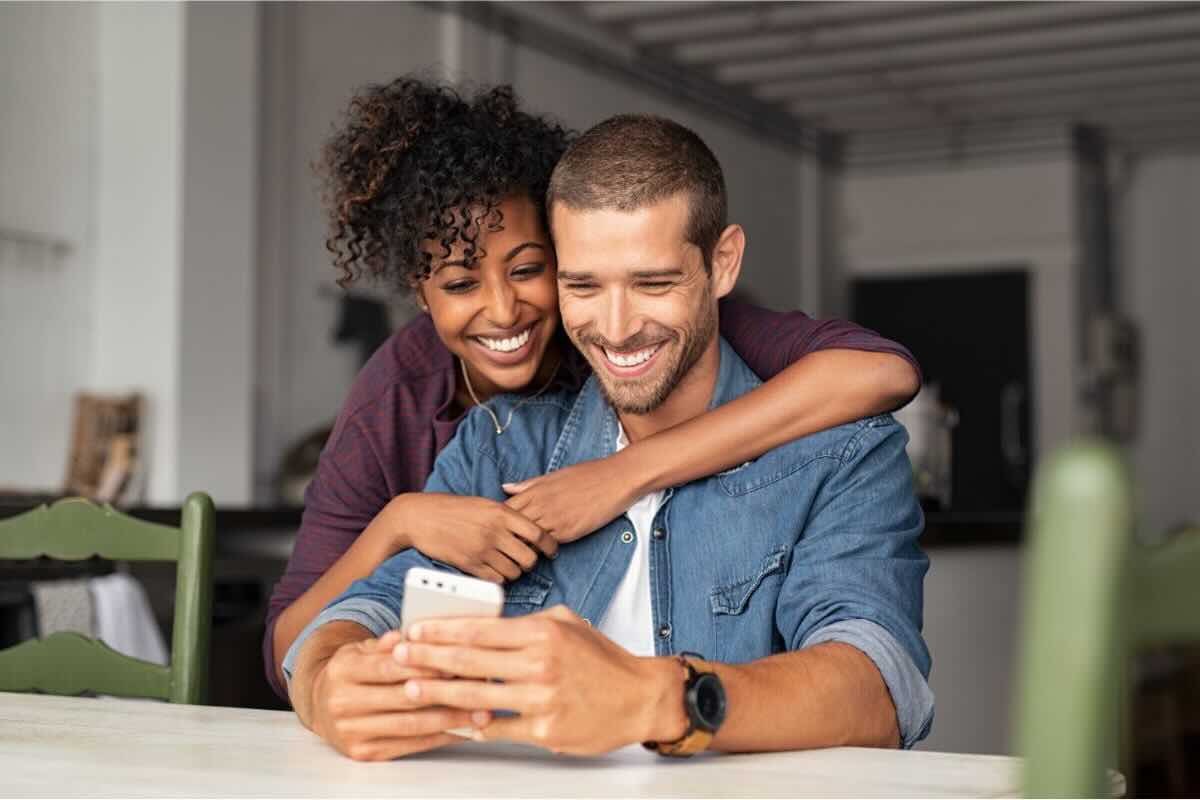 Coppia sorridente guarda su smartphone