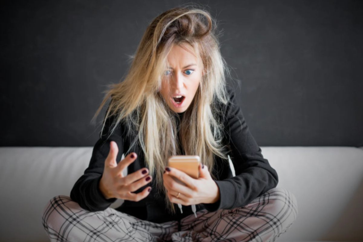 donna arrabbiata con in mano il cellulare
