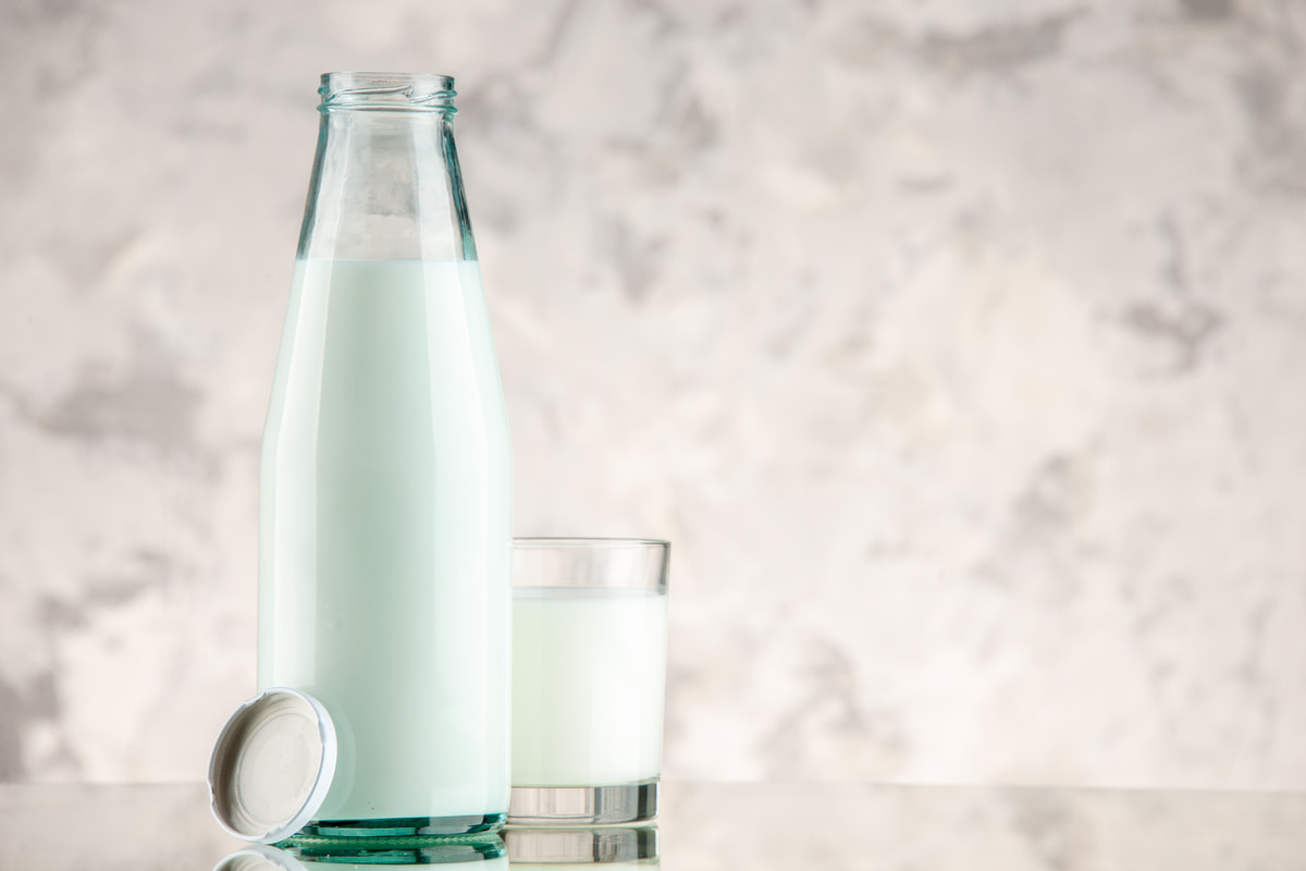 Bottiglia di latte e bicchiere pieno accanto