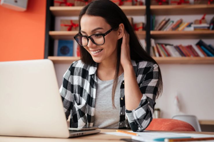 ragazza che sorride seduta davanti al computer