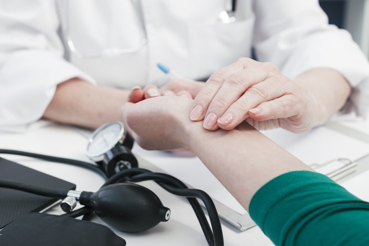 medico che sente il polso di una paziente