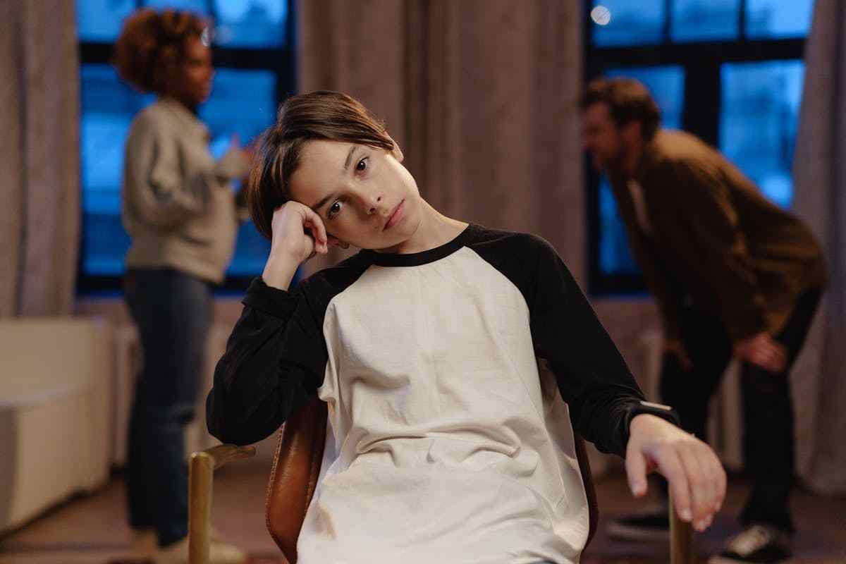 ragazzo avvilito con genitori che litigano sullo sfondo